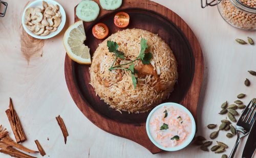 indian-traditional-dish-with-rice-cashew-nuts-sauce-lemon-vegetables-coriander-leaf-wooden-tray_613910-21742