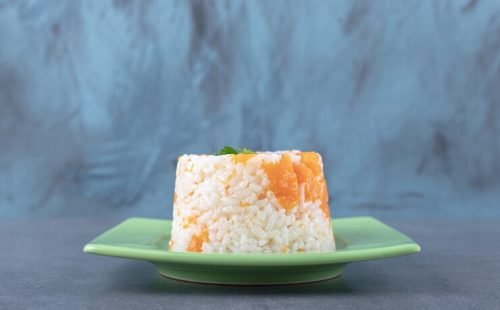 small-portion-carrot-rice-marble-surface_114579-63952
